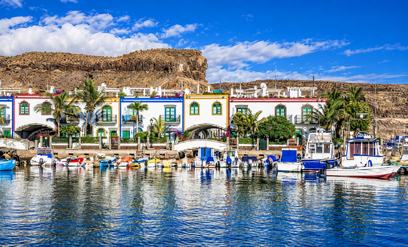 Puerto de Mogán, Gran Canaria, con casas junto al puerto, barcos y la montaña al fondo